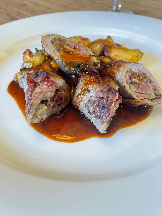 Gefüllte, gerollte Fleischstücke mit Bratkartoffeln und dunkler Sauce