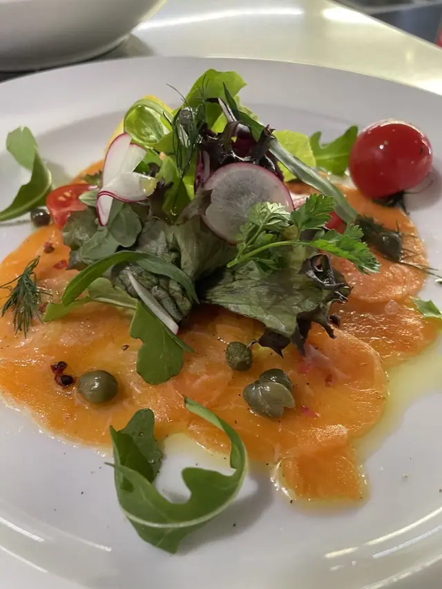 Saiblingscarpaccio mit Salat, Radieschen, Kapern und Kirschtomate